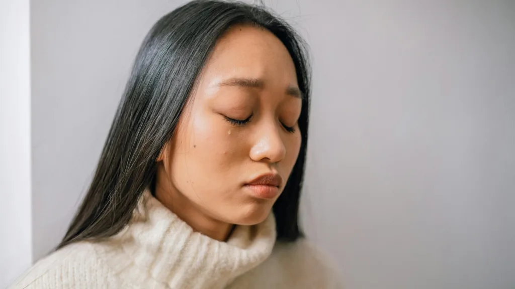 Woman with eyes closed appearing deep in thought or emotional processing, representing abreaction during EMDR therapy
