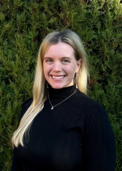 Callie Diz, therapist at Bright Spot Counseling, smiling outdoors in front of greenery