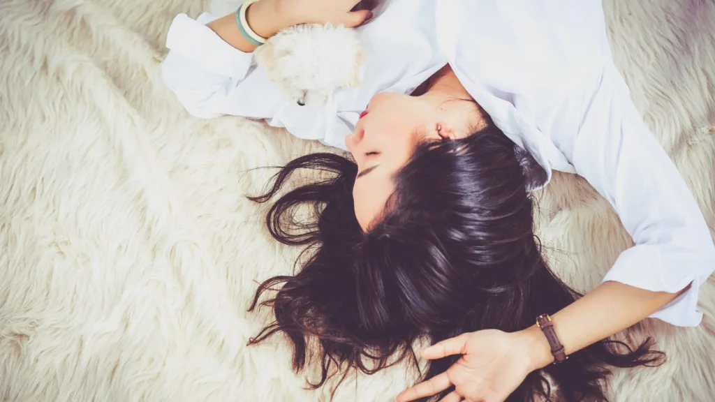 Peaceful woman resting on soft bedding, symbolizing improved sleep through Cognitive Behavioral Therapy for Insomnia
