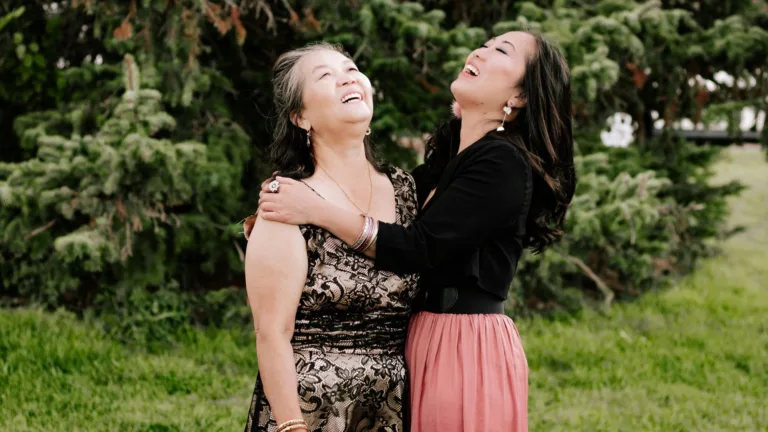 Two women laughing together in a park, symbolizing connection, healing, and challenging cultural stigma around psychiatric medication