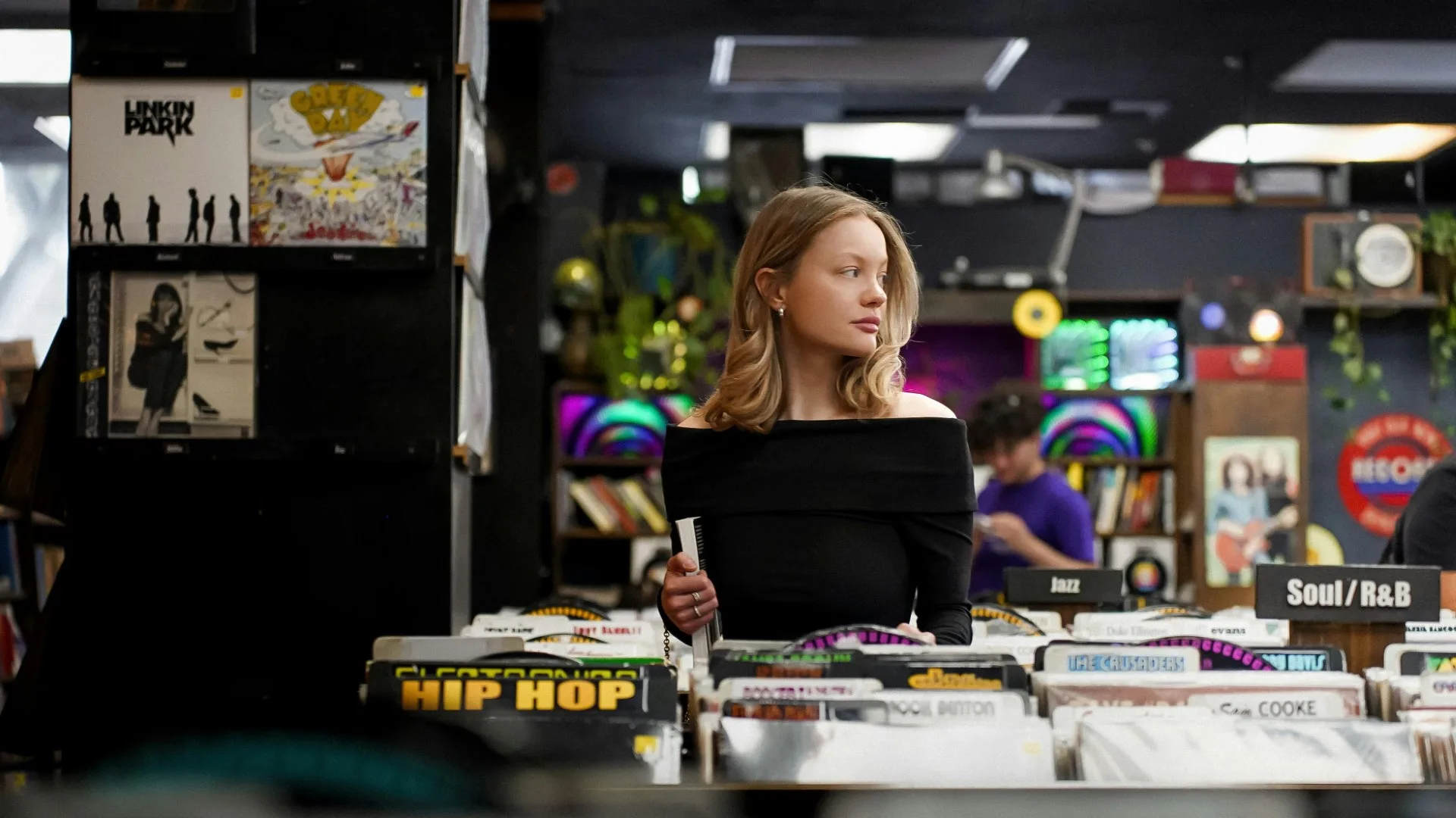 Young woman browsing records, appearing lost in thought – symbolizing feeling stuck in your 20s in Michigan