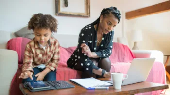 Mother and son at home looking at a tablet and laptop, representing families searching for a child therapist in Metro Detroit