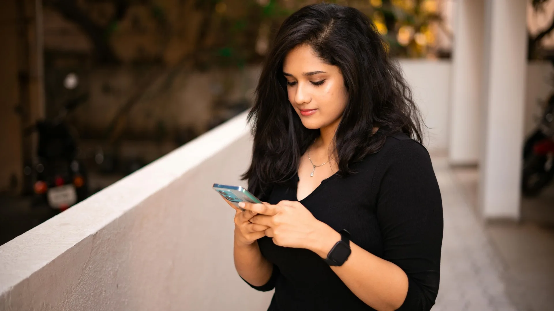 Woman looking at phone outdoors, representing mindful screen use and digital balance