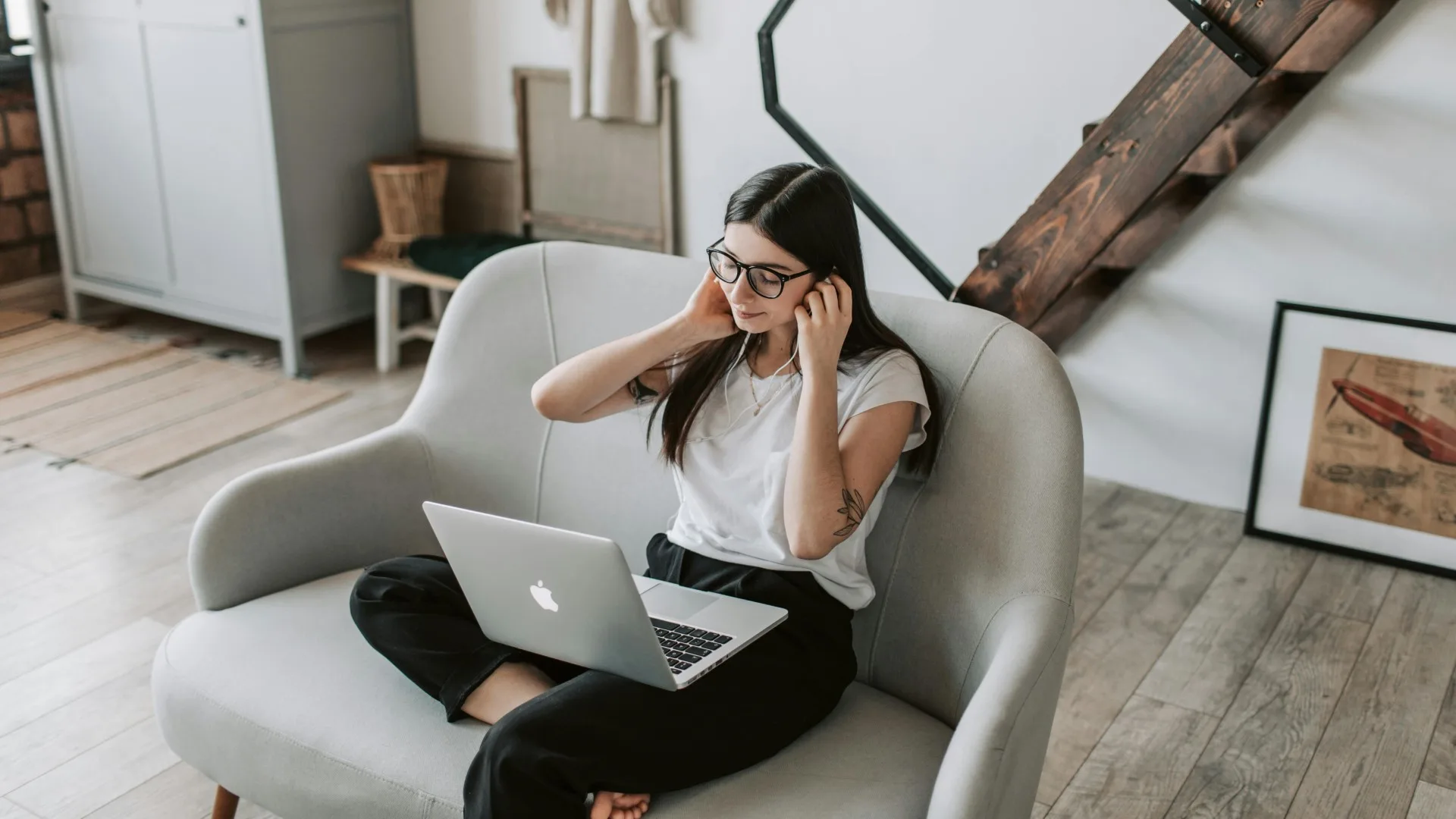 Young woman attending a virtual therapy session from home, wearing a headset and using a laptop