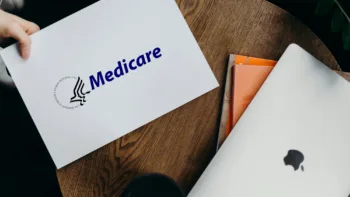 Medicare paperwork next to laptop and notebook, representing questions about mental health coverage