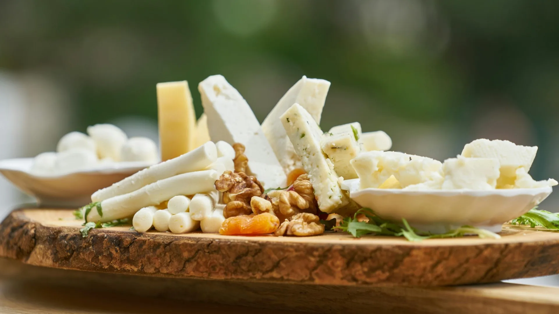 Assorted cheeses, nuts, and fruits on a wooden board — symbolizing how small offerings like vulnerability can initiate authentic human connection