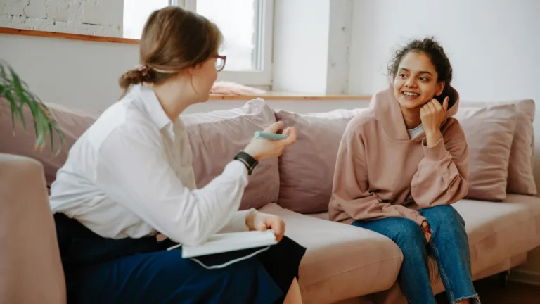 Young woman smiling while speaking with her therapist during a culturally affirming therapy session