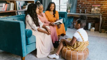 Women talking with a young girl in a cozy living room, symbolizing how DBT skills can benefit people of all ages