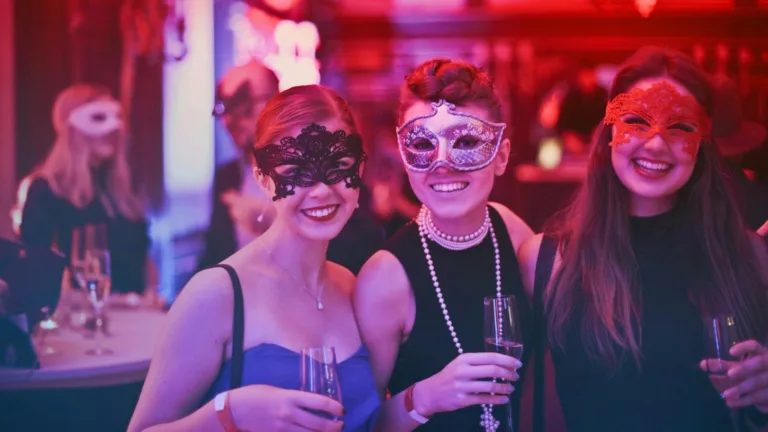 Three women wearing masquerade masks at a lively party, representing social connection and emotional boundaries