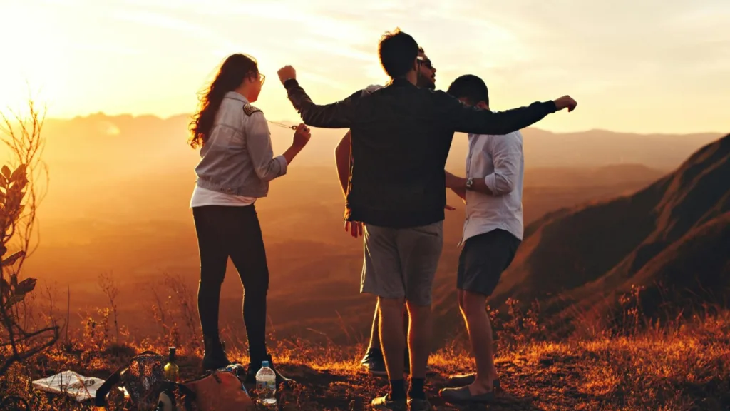 Group of adults dancing together outdoors at sunset, expressing joy, stress relief, and emotional freedom