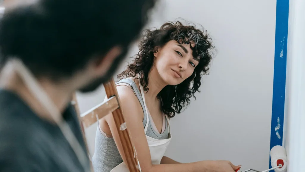 Young woman glancing at a man while painting, illustrating emotional dynamics in a codependent relationship