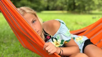 Young girl relaxing in a hammock outdoors, representing EMDR therapy for children and teens in Michigan