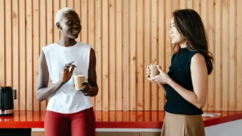 Two women having a conversation over coffee, symbolizing social support or unwanted advice