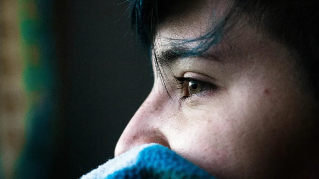 Close-up of a person looking out a window, symbolizing emotional healing through half-day EMDR therapy in Farmington Hills, MI