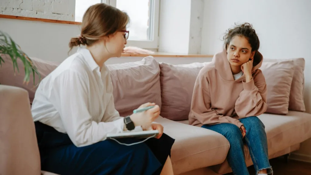 Therapist engaging in conversation with a young woman during an Internal Family Systems (IFS) therapy session