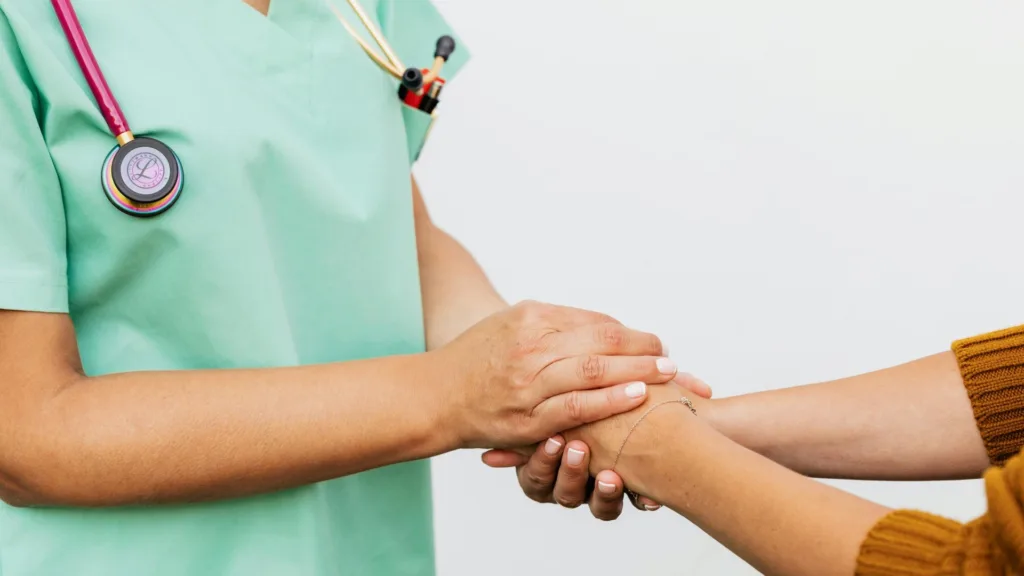 Michigan primary care provider holding hands with a patient to support integrated mental health and medical care