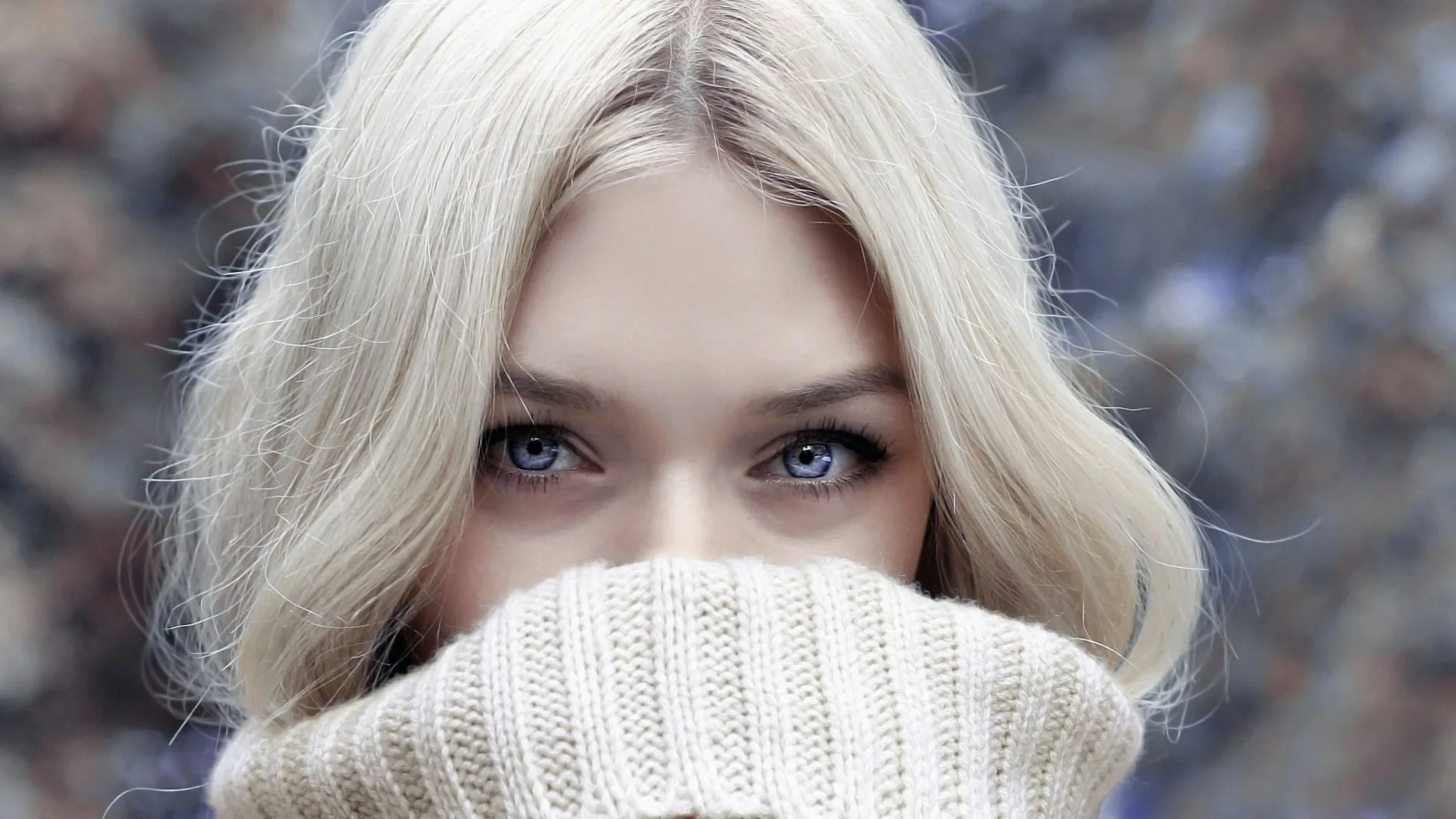 Person gazing directly with only eyes visible above a sweater, suggesting cautious curiosity or emotional introspection