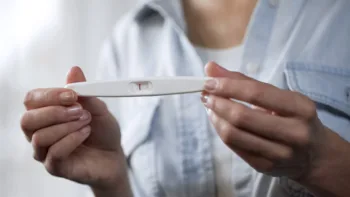Person holding a negative pregnancy test, reflecting infertility challenges and emotional vulnerability