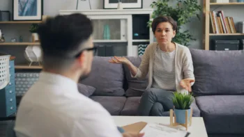 Woman talking to a therapist in a modern counseling office, expressing confusion or seeking clarity