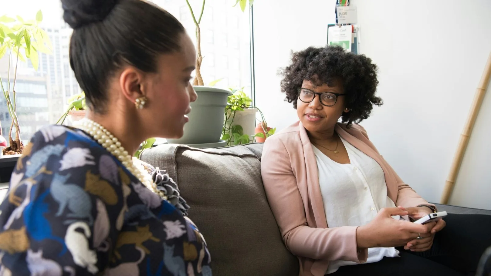 Two women talking on a couch, illustrating the experience of receiving unsolicited advice in a personal conversation