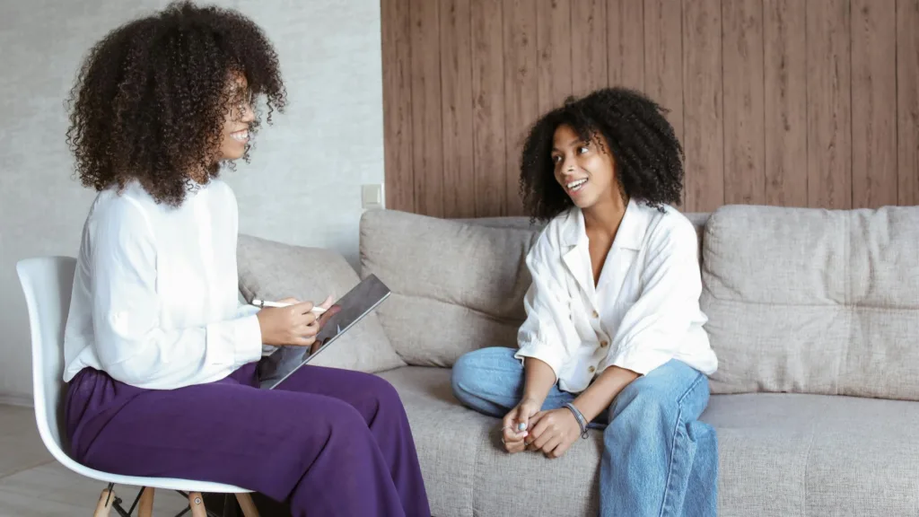 Therapist and client talking during a casual therapy session on a couch