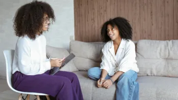Therapist and client talking during a casual therapy session on a couch