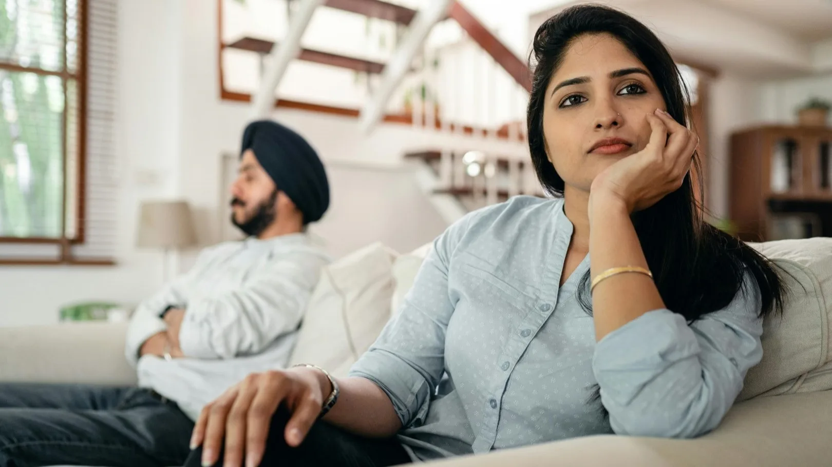 South Asian couple sitting in silence, emotionally disconnected — exploring avoidance in online therapy MI